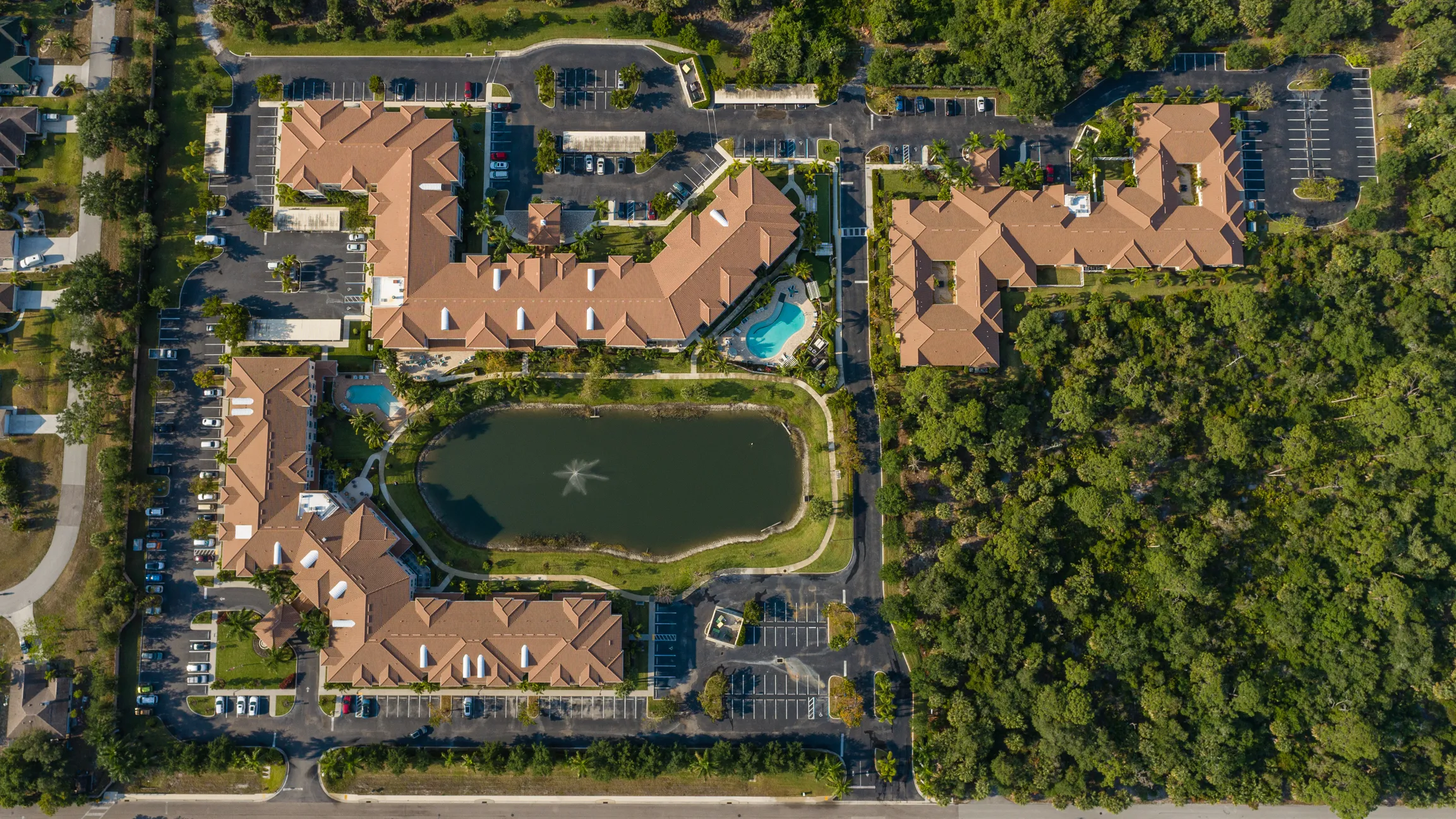 overhead aerial image of assisted living community with pools and lake